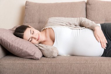 Hamile kadın kanepede dinleniyor..