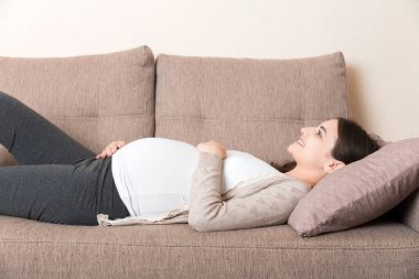 Hamile kadın kanepede dinleniyor..