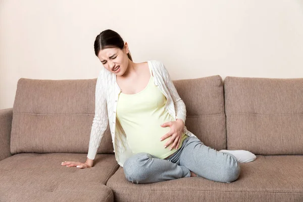 Wanita Hamil Dengan Perut Yang Sakit Sofa Rumah — Stok Foto