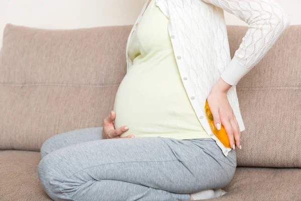 Těhotná Žena Trpí Bolestí Zad Drží Horkou Láhev Nebo Teplejší — Stock fotografie