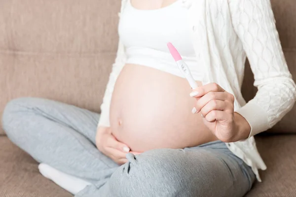 Úsměv Žena Při Pohledu Těhotenský Test Pozitivním Výsledkem Ruce Doma — Stock fotografie