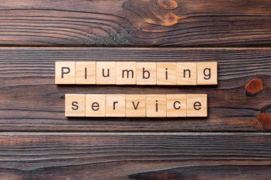 Tesisat servisi kelimesi ahşap blokta yazılı. Tesisat servisi metni çimento masasında desing, konsept için.