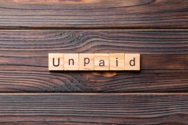 Tahta blokta ödenmemiş kelime. Deksing, konsept için çimento masadaki Ödenmemiş metin.