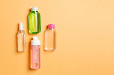 Kozmetik SPA marka modeli, fotokopi alanı olan üst görünüm. Renkli arka planda duran krema tüpleri ve kavanozları..