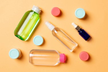 Kozmetik SPA marka modeli, fotokopi alanı olan üst görünüm. Renkli arka planda duran krema tüpleri ve kavanozları..