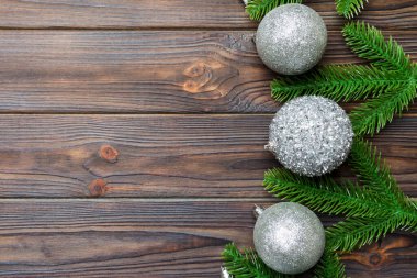 Şenlik baloları, köknar ağacı ve ahşap arka planda Noel süslemeleri. Kopya alanı ile yeni yıl süsü konseptinin en üstü görünümü.