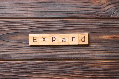 Tahta bloğa yazılmış bir kelime. İfadeniz için çimento masadaki ExPAND metni.