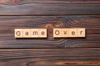 Tahta blokta yazılı oyun bitti. Masada oyun üzeri metin, konsept.