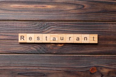Restoran kelimesi ahşap blokta yazılı. Restoran metni çimento masasında desing, konsept için.