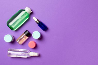 Kozmetik SPA marka modeli, fotokopi alanı olan üst görünüm. Renkli arka planda duran krema tüpleri ve kavanozları..