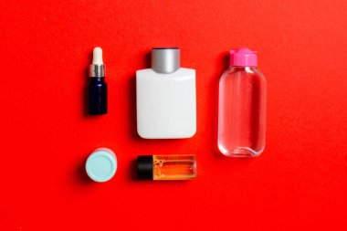 Kozmetik SPA marka modeli, fotokopi alanı olan üst görünüm. Renkli arka planda duran krema tüpleri ve kavanozları..