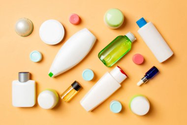Plastik gövde bakımı şişesi düz kompozisyonu ve renkli arka plan boşluğuna kozmetik ürünler dizayn edilmişti. Beyaz Kozmetik kapları kümesi, kopya alanı ile üst görünüm.