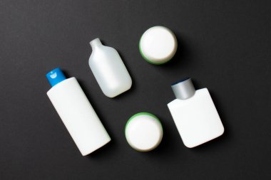 Kozmetik SPA marka modeli, fotokopi alanı olan üst görünüm. Renkli arka planda duran krema tüpleri ve kavanozları..