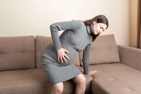 Senhora Grávida Ter Massagem Barriga Inferior Sentado Sofá Interior Gravidez — Fotografia de Stock