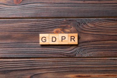Tahta blokta GDPR kelimesi yazıyor. Genel Veri Koruma Yönetmeliği metni desing, konsept için çimento tablo üzerinde.