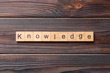 Tahta blokta yazılı bilgili bir kelime. Beton masadaki bilgi metni desing, konsept için.