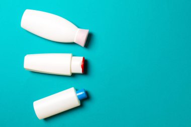 Renkli arkaplanda izole edilmiş Beyaz Kozmetik konteynırları seti, fotokopi alanı ile üst görünüm. Senin için bir grup plastik kaplar ve boş bir yer tasarladın..