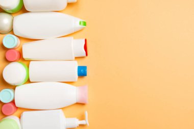 Plastik gövde bakımı şişesi düz kompozisyonu ve renkli arka plan boşluğuna kozmetik ürünler dizayn edilmişti. Beyaz Kozmetik kapları kümesi, kopya alanı ile üst görünüm.