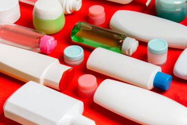 Plastik gövde bakımı şişesi düz kompozisyonu ve renkli arka plan boşluğuna kozmetik ürünler dizayn edilmişti. Beyaz Kozmetik kapları kümesi, kopya alanı ile üst görünüm.