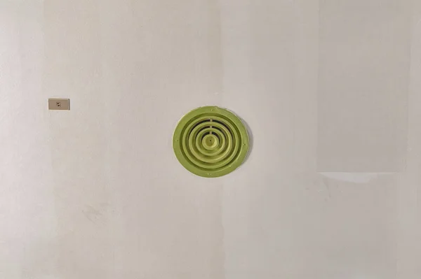 Green round outlet of air condition on ceiling with copy space.