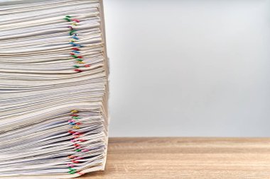 Beyaz arkaplan ve fotokopi alanı olan renkli ataç içeren bir yığın kağıt satışı raporu. Yığınla belge çok çalışmak kadar yüksek. İş ve finans kavramı başarılı.