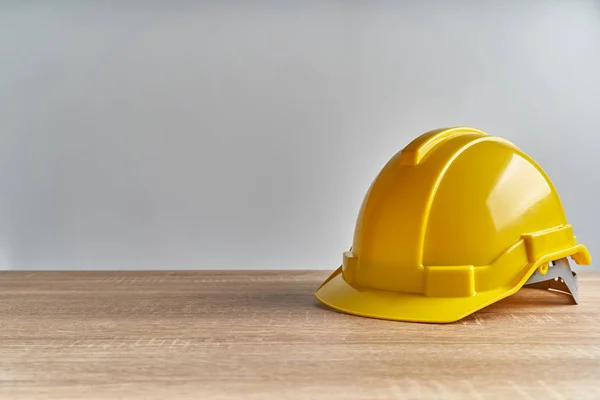 将黄色的工程师帽放在白色背景和复制空间的木制桌子上 工业上成功的概念摄影 — 图库照片