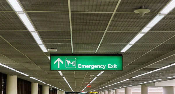 Segnale bordo informazioni uscita di emergenza terminal aeroporto internazionale Fotografia Stock