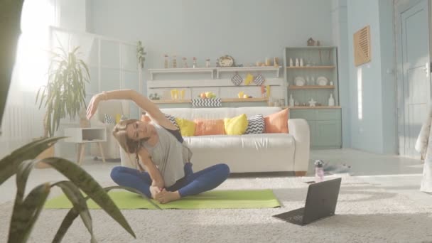 Flexibilní tělový trénink časně ráno s laptopem — Stock video