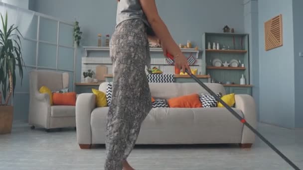 一个年轻的女孩在打扫房子，和一个叫MOP的人跳舞时很开心 — 图库视频影像