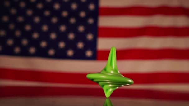 Bunten snurrar och sedan faller mot bakgrund av den amerikanska flaggan. — Stockvideo