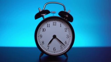 Mavi arkaplanda siyah alarm saati. 