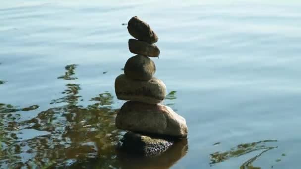 Piramide van stenen bij het water. symboliseert zen, harmonie, balans. Positieve energie. — Stockvideo