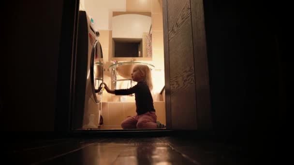 En liten flicka hjälper sin mamma tvätta kläder. — Stockvideo