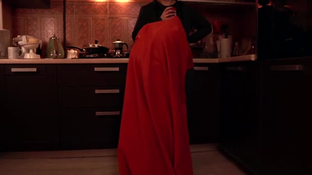 एक छोटी लड़की रसोई में भूत के रूप में पोज़ कर रही है — स्टॉक वीडियो