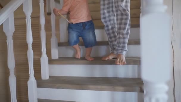 Η μητέρα βοηθάει τον μικρό της γιο να κατέβει τις σκάλες. — Αρχείο Βίντεο