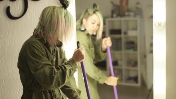 Beautiful Happy Girl Sings And Dances In Front Of A Mirror with a mop — Stock Video