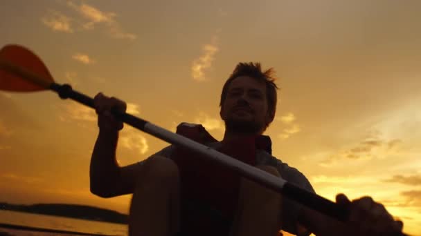 Sillouette de hombre kayak en el lago al atardecer. Relajante en la naturaleza — Vídeos de Stock