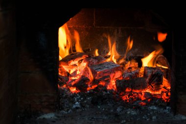 kret üzerinde ahşap şöminede yanan alev.