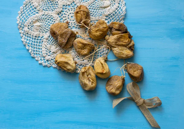 Gäng torkade fikon på på en stickad servett på en blå tabell. Torkad frukt. — Stockfoto