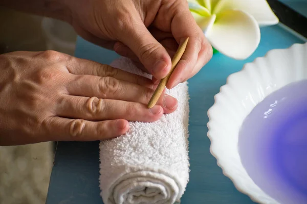 Manicure at home. Care of the cuticle, treatment of the cuticle with orange stick.