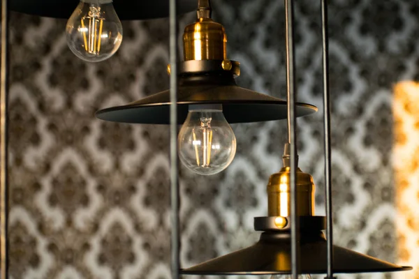 Black decorative lamps hangs from the ceiling. A modern chandelier at home.