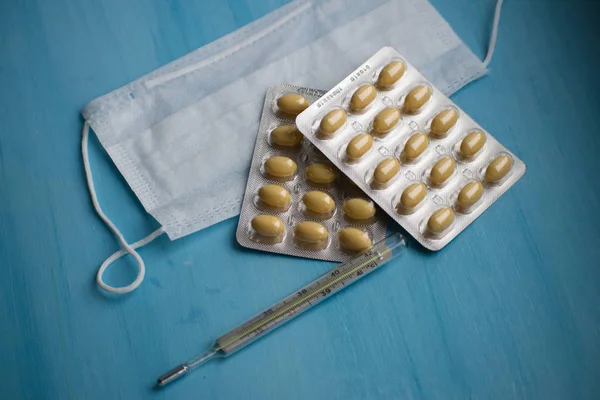 Pastillas Termómetro Mascarilla Médica Sobre Fondo Azul Vista Superior Primeros —  Fotos de Stock