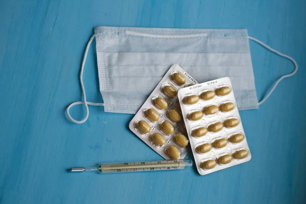 Tabletták Hőmérő Orvosi Maszk Kék Háttérrel Felülnézet Elsősegély Ellátás Alatt — Stock Fotó