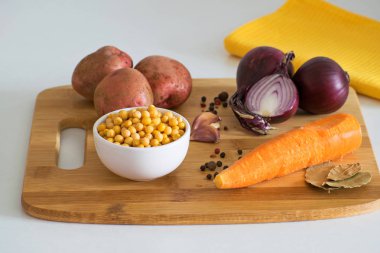 Bezelye çorbası malzemeler: patates, havuç, soğan, sarımsak, biber ve bezelye bir ahşap tahta üzerinde. Rustik tarzı.