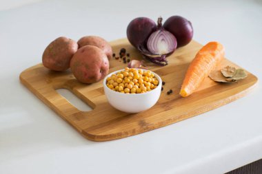 Bezelye çorbası malzemeler: patates, havuç, soğan, sarımsak, biber ve bezelye bir ahşap tahta üzerinde. Rustik tarzı.