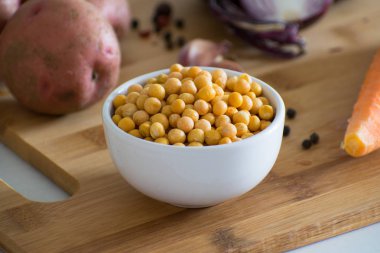 Sebze çorbası için malzemeler. Bezelye çorbası malzemeler: patates, havuç, soğan, sarımsak, biber ve bezelye ahşap oyun tahtası.