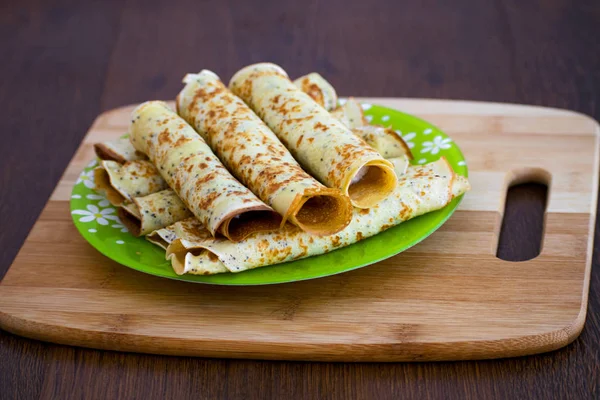 Krep rulo süzme peynir ile. Ahşap oyun tahtası Peynirli Krep. Maslenitsa.