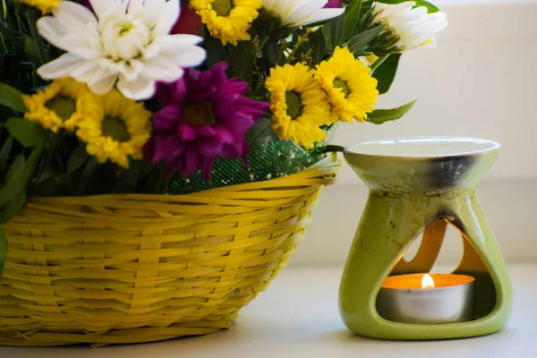 Oil burner with chrysanthemums. Oil, aromatherapy burner, flowers and candles for spa and relaxation.