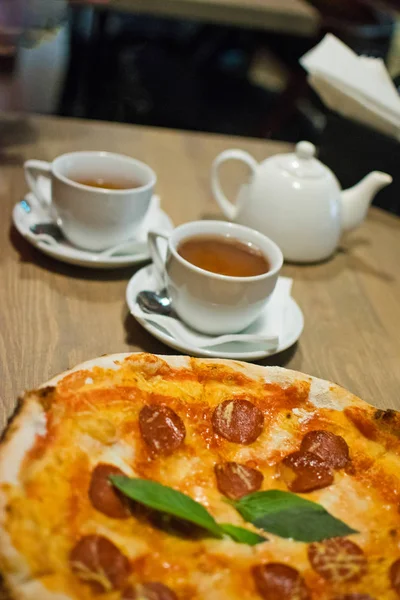 Lezzetli geleneksel İtalyan biberli pizza beyaz plaka üzerinde.