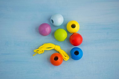 Gelişimsel çocuk oyuncak. Bir ip üzerinde renkli ahşap toplar. Renkli ahşap bebek boncuk.